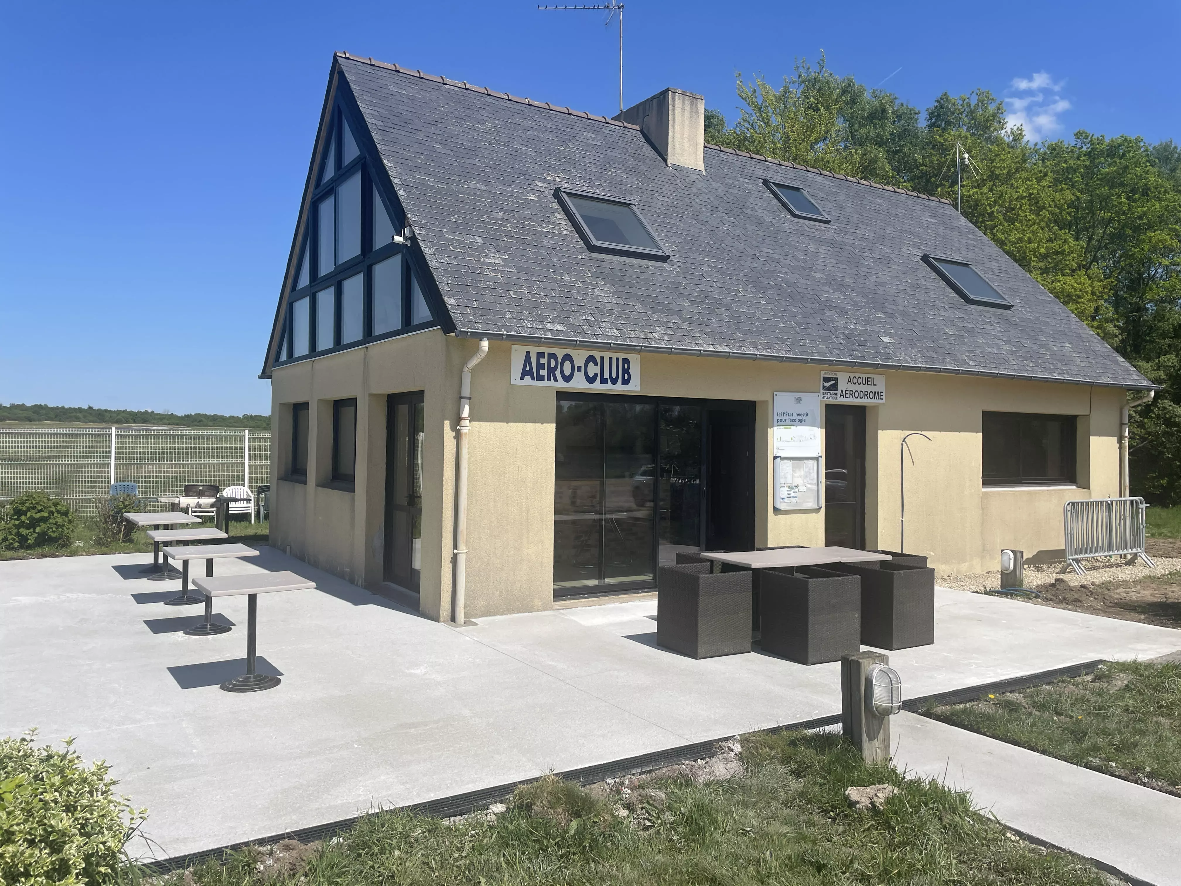 unnamed-24 Vue extérieure du Club House de l’Aérodrome Bretagne Atlantique avec terrasse et vue sur les pistes.
